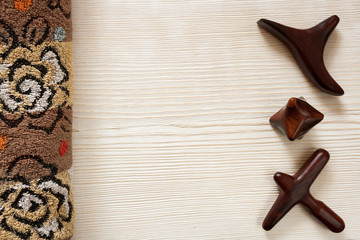 SPA and massage concept. Rolled terry towel and wooden massage sticks are lying on wooden background.