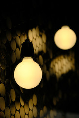 Golden lightbulbs against a black and yellow shimmery background