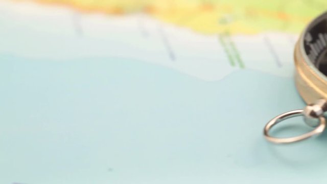 concept of travel, adventure, expedition, business, choice and possibilities - a golden compass lying on an abstract map with a red arrow that shows the direction