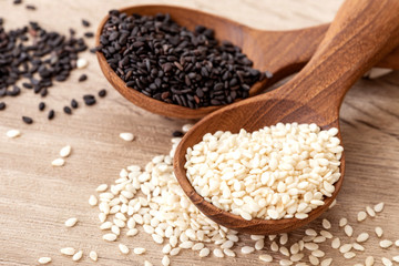 organic Black and white sesame seeds in a wooden spoon , top view or overhead shot - 213917433