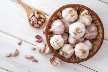 Close up group of garlic on a white wooden table board , top view or overhead shot with copy space © Cozine