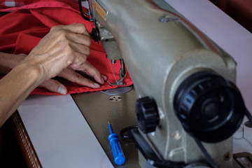 Woman's hands sewing fabric  repairs on old sewing