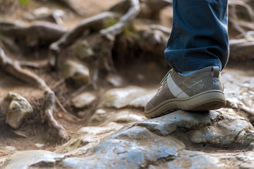 foot tourist on slippery stones close-up in the hike