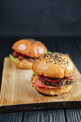 homemade juicy burgers on wooden board. Street food, fast food.