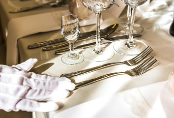 Kelnerka precyzyjnie przygotowuje zastawę do wesela	