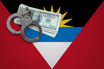 Antigua and Barbuda flag  with handcuffs and a bundle of dollars. The concept of breaking the law...