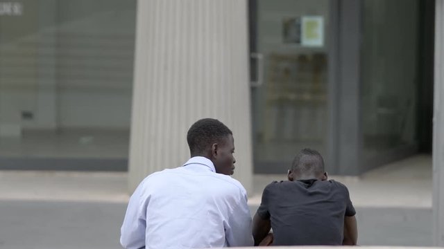 african friend consoling his sad friend. Friendship,support- outdoor