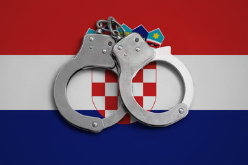 Croatia flag  and police handcuffs. The concept of observance of the law in the country and...
