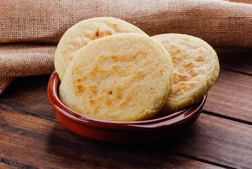 Plate with arepas on a rustic wooden background