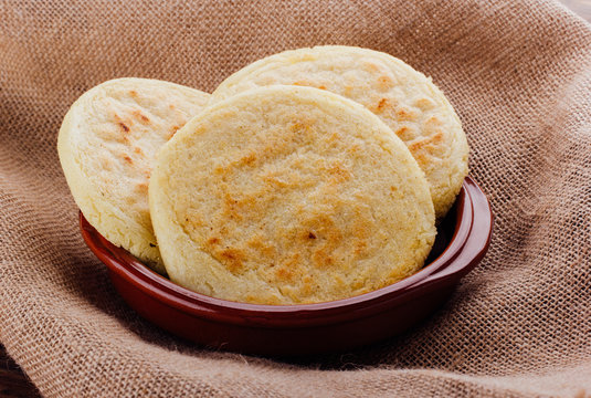 Plate with arepas on a rustic wooden background