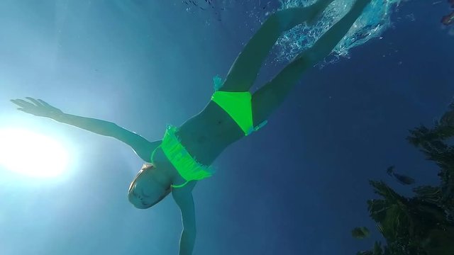 Teen girl swimming underwater with father. Father and his daughter swimming in pool at aquapark
