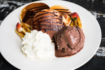 top view Pancake and Chocolate icing on black wooden table.