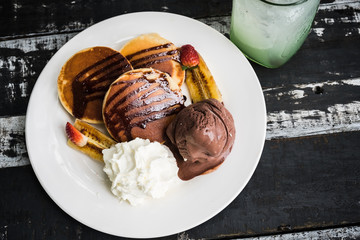 top view Pancake and Chocolate icing on black wooden table.