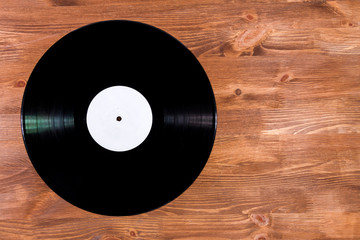 Black color vinyl record on brown wooden background