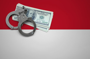 Indonesia flag  with handcuffs and a bundle of dollars. The concept of breaking the law and thieves...