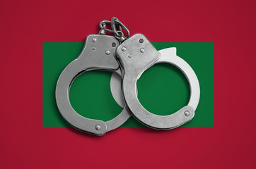 Maldives flag  and police handcuffs. The concept of observance of the law in the country and...
