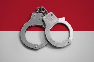 Indonesia flag  and police handcuffs. The concept of observance of the law in the country and...