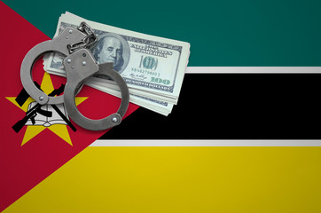 Mozambique flag  with handcuffs and a bundle of dollars. The concept of breaking the law and...