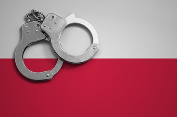 Poland flag  and police handcuffs. The concept of crime and offenses in the country