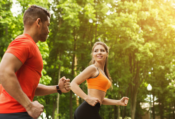 Naklejka premium Athletic couple running together in park