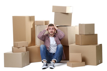 Young man with cardboard boxes on white background