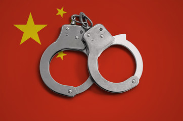 China flag  and police handcuffs. The concept of observance of the law in the country and...