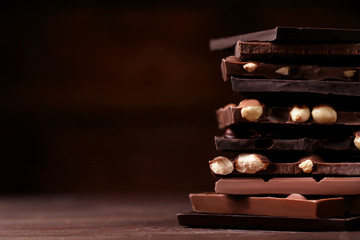 Chocolate pieces with hazelnuts on wooden table