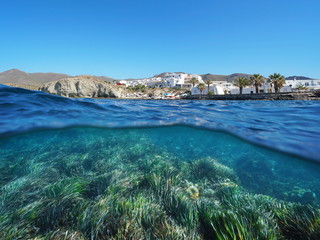 Fototapeta na wymiar Typical fishing village La Isleta del Moro on the Mediterranean coast with seagrass underwater sea, split view above and below water surface, Cabo de Gata-Níjar, Almeria, Andalusia, Spain