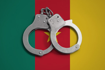 Cameroon flag  and police handcuffs. The concept of observance of the law in the country and...