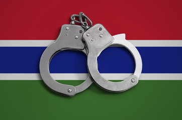 Gambia flag  and police handcuffs. The concept of observance of the law in the country and...