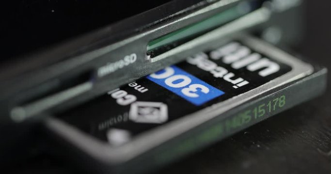 A Compact Flash card being inserted into a multi card reader.