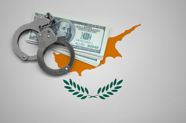 Cyprus flag  with handcuffs and a bundle of dollars. The concept of breaking the law and thieves...