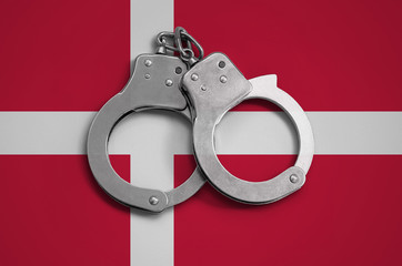 Denmark flag  and police handcuffs. The concept of observance of the law in the country and...