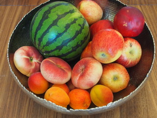 Sommerliche Obstschale mit Früchten auf Holztisch