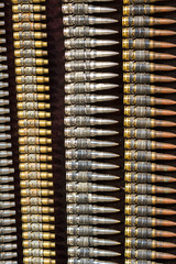 Brightly polished bullets on a black bakcground, forming bands and almost abstract patterns