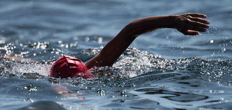 Unknown swimmer at sea, swimming crawl in blue sea,training for triathlon