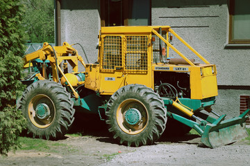 Fototapeta na wymiar A small yellow tractor for many works