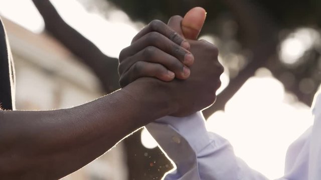 close up on black people greetings. Shaking hands - slow motion