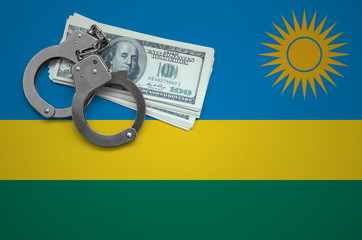 Rwanda flag  with handcuffs and a bundle of dollars. The concept of breaking the law and thieves...