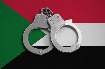 Sudan flag  and police handcuffs. The concept of observance of the law in the country and...