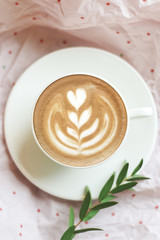 Top View of Cappuccino Coffee Cup with Green Branch