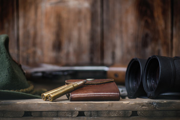 Professionele jagersuitrusting voor de jacht. Detail over de munitie. Houten zwarte achtergrond met geweer, hoed en andere uitrusting voor de jacht.