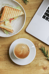 Composition with Coffee, Laptop, Sandwich and Branch of Pistachi