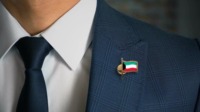 Businessman Walking Towards Camera With Country Flag Pin - Kuwait