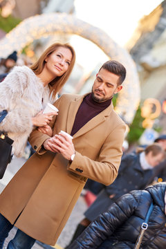 A beautiful young couple drinking mulled wine in a christmas market.