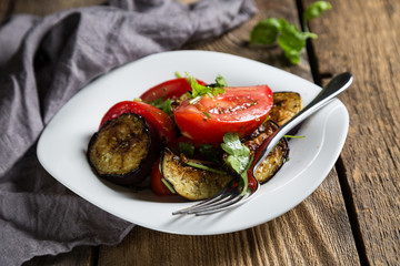 Salad of baked eggplants and fresh tomatoes with parsley
