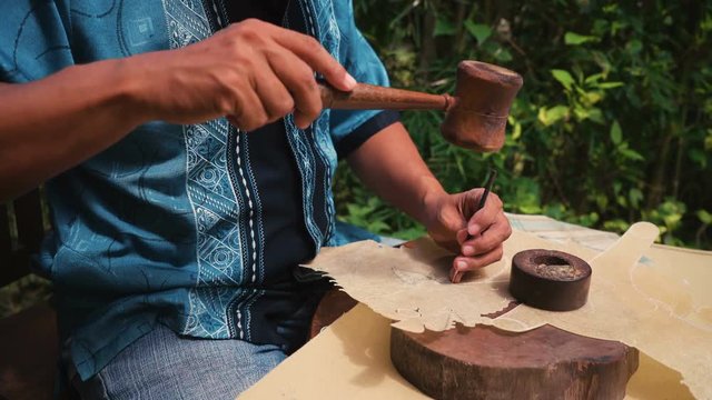 Close up of leather puppet Wayung kulit maker man working outdoors in Jogjakarta, Indonesia