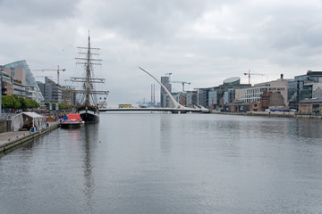 Fototapeta na wymiar Old sailing ship on River Liffey, Samuel Beckett Bridge and the CCD, Dublin, Ireland