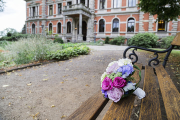 Fototapeta na wymiar Wedding bouquet of roses on bench in park