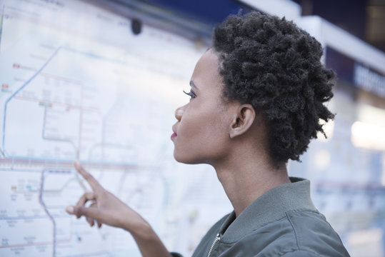 Germany, Munich, profile of young woman looking at map
